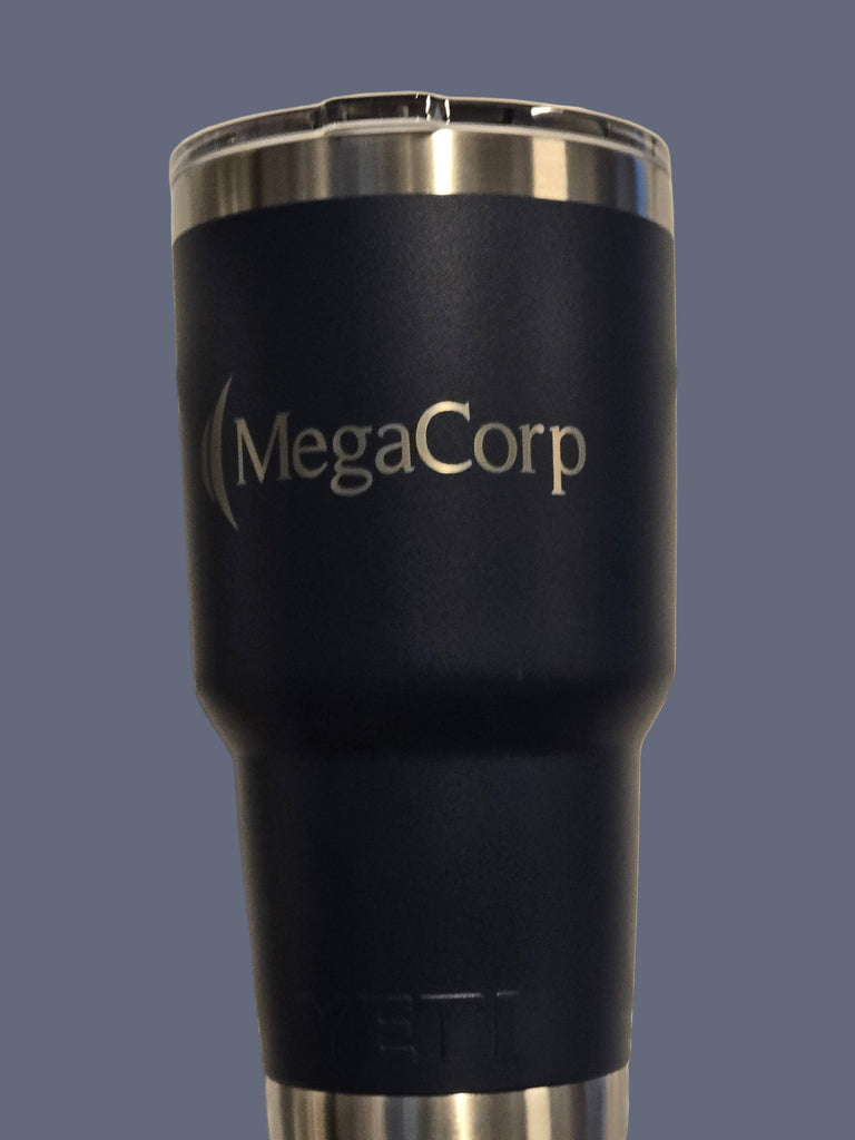 Black insulated tumbler with 'MegaCorp' branding on a metallic surface